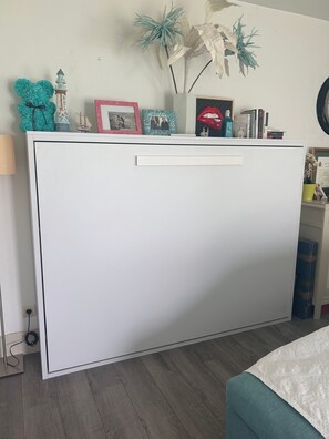A white cabinet with decorative items on top, a lamp, and a framed picture on the wall. - Apartment 'Modern  Cozy Just 5 Mins From' with Shared Pool, Wi-Fi and Air Conditioning (Marbella)