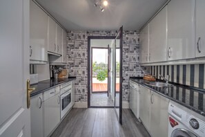 A modern kitchen with white cabinets, a stainless steel sink, and a built-in dishwasher. - Apartment 'Modern  Cozy Just 5 Mins From' with Shared Pool, Wi-Fi and Air Conditioning (Marbella)