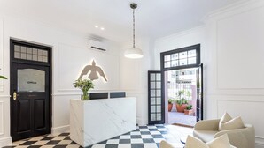 A reception area with a marble counter, a black door labeled 'Office,' a large illuminated sculpture, and a checkered floor. - Spacious 4-bedroom apartment in peaceful Cape Town with AC (Cape Town)