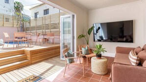 A modern living room with a TV, comfortable seating, a pool, and a staircase leading to an outdoor area. - Spacious 4-bedroom apartment in peaceful Cape Town with AC (Cape Town)