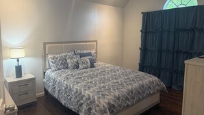 A bedroom with a bed, nightstand, lamp, and a window with curtains. - Niarys house houston and Missouri City (Missouri City)