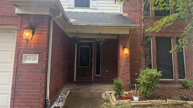 A two-story house with a brick facade, a covered front porch with potted plants, and a visible door number. - Niarys house houston and Missouri City (Missouri City)