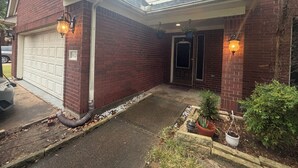 A two-story house with a garage, a front door, and a small porch area. - Niarys house houston and Missouri City (Missouri City)