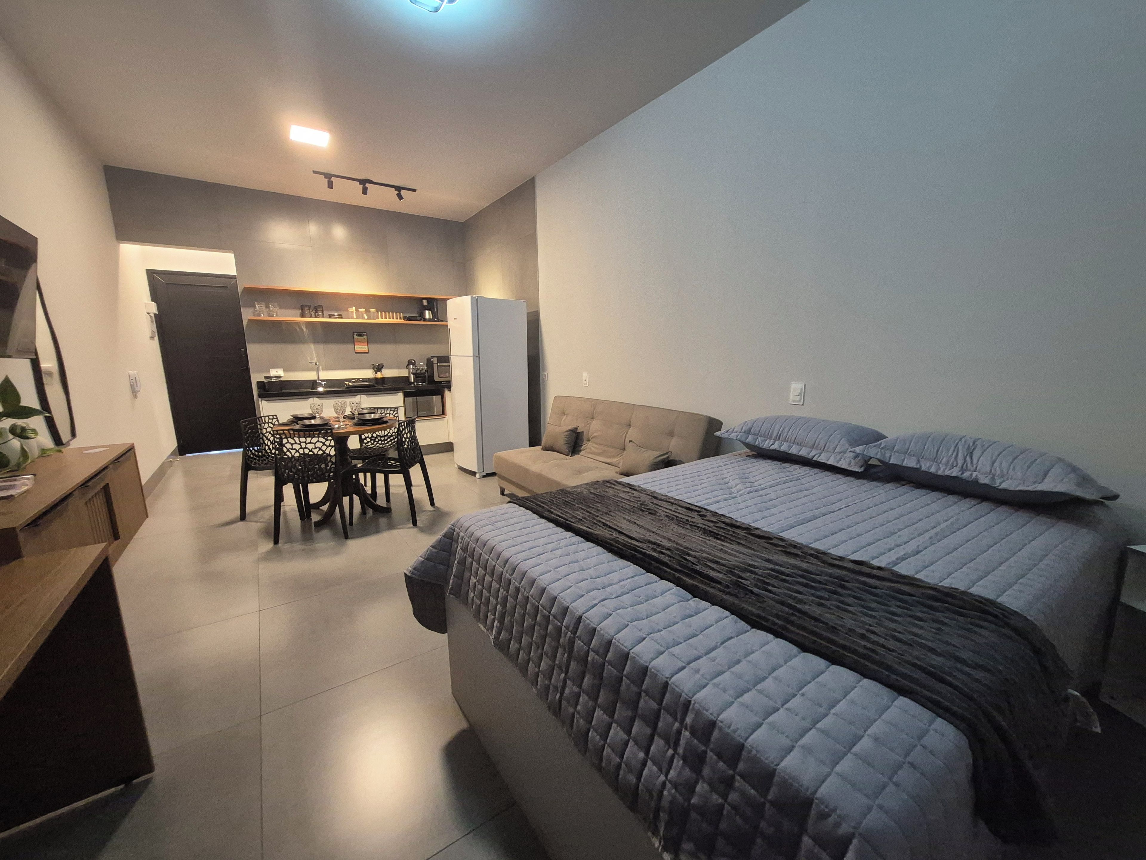 Une chambre à coucher de taille réduite, comprenant un lit, des tables de chevet et un petit bureau.