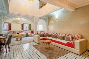 Un salon spacieux comprenant un canapé, une table basse et un coin repas avec des chaises.