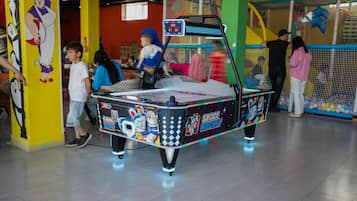 Un área de juegos interior con una máquina de hockey espacial.