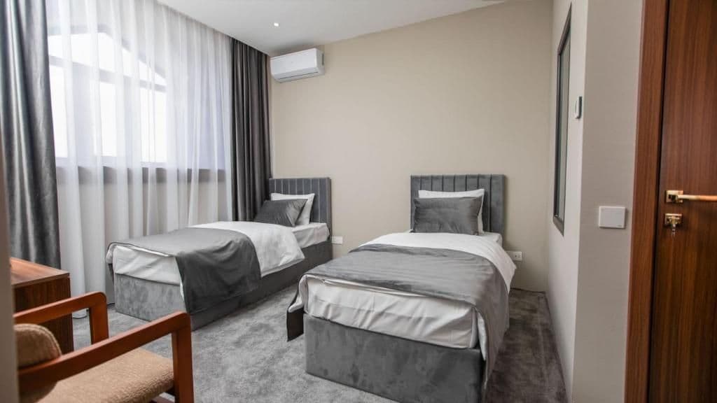 Una habitación de hotel con dos camas, un escritorio y una silla.