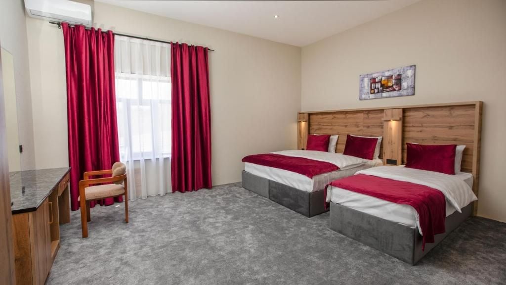 Una habitación de hotel con dos camas, un escritorio y una silla.