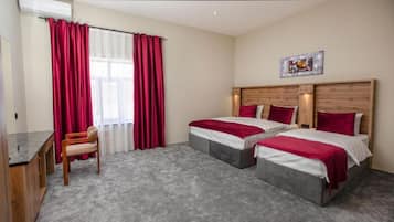 Una habitación de hotel con dos camas, un escritorio y una silla.