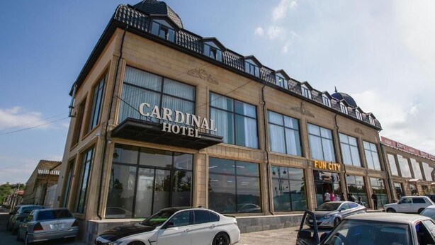 A hotel with a prominent sign, large windows, and a parking lot. - Cardinal Hotel Quba (Quba)
