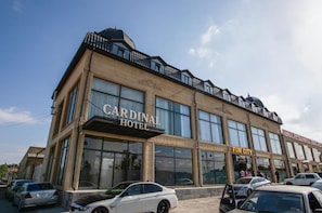 A hotel with a prominent sign, large windows, and a parking lot. - Cardinal Hotel Quba (Quba)