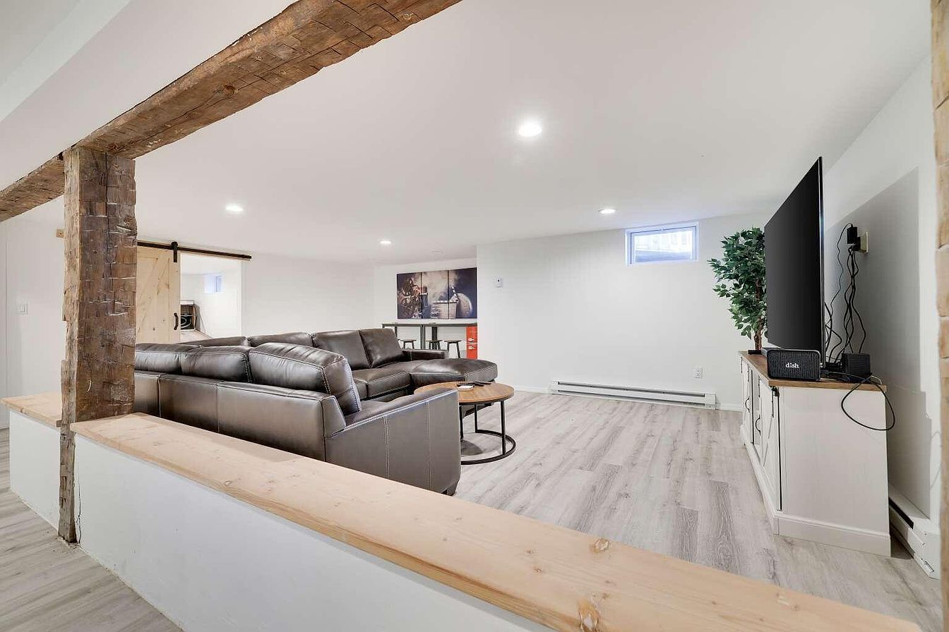 A modern living room with a sectional sofa, a coffee table, and a flat-screen TV.
