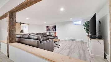 A modern living room with a sectional sofa, a coffee table, and a flat-screen TV.