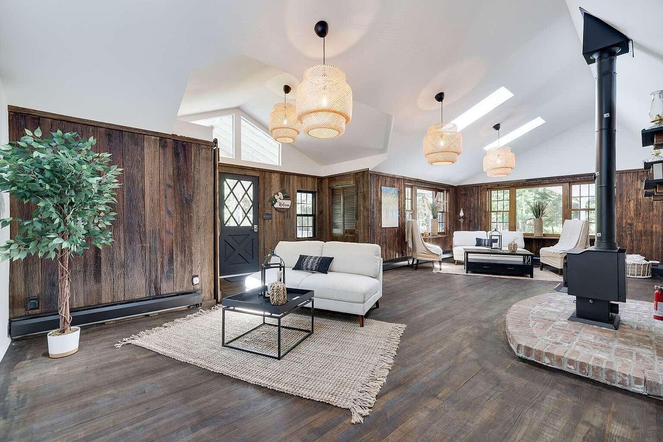 A spacious living area with a white sofa, a coffee table, and a fireplace.