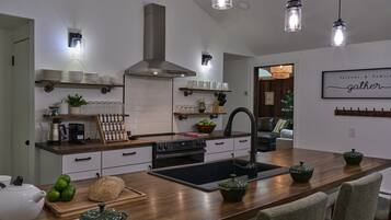 A modern kitchen with a central island, stainless steel appliances, and pendant lighting.