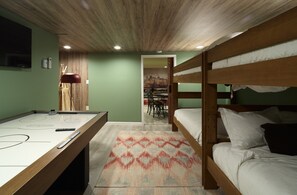 Una habitació amb llits superposats, taula de bitlles i zona de menjador.