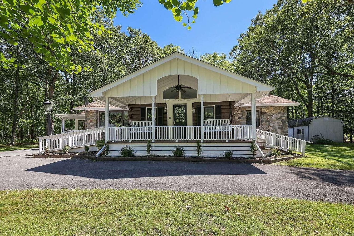A two-story building with a porch and a covered front entrance.