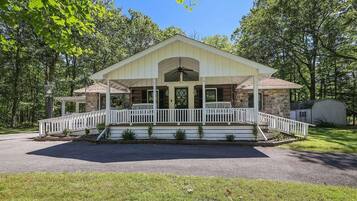 A two-story building with a porch and a covered front entrance.