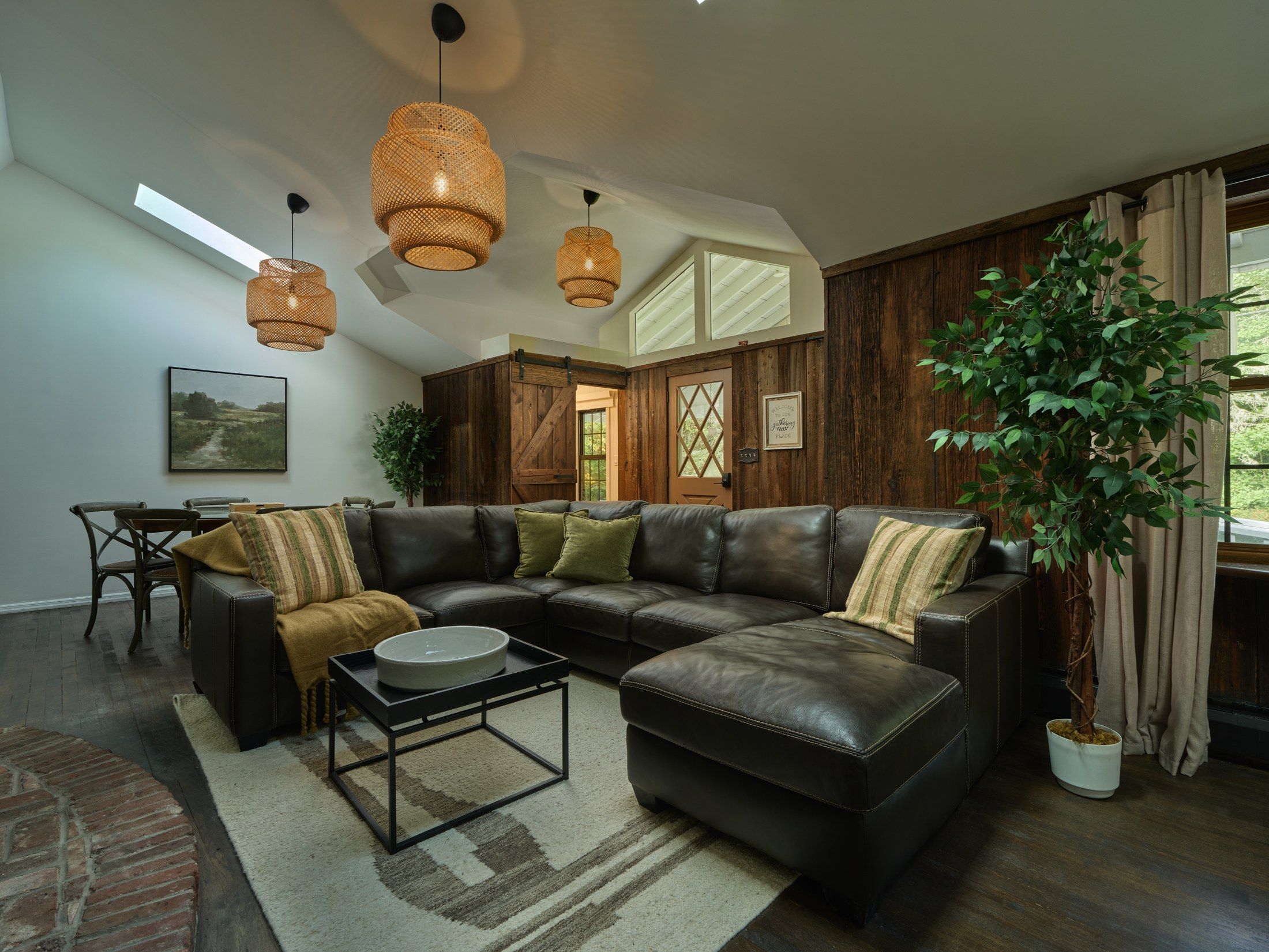 A modern living room with a sectional sofa, a coffee table, and a large potted plant.