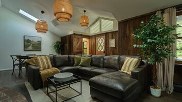 A modern living room with a sectional sofa, a coffee table, and a large potted plant.