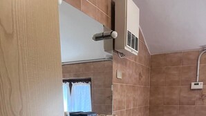 Ein Badezimmer mit Waschbecken, zwei Toiletten, einem Spiegel und einer Dusche.