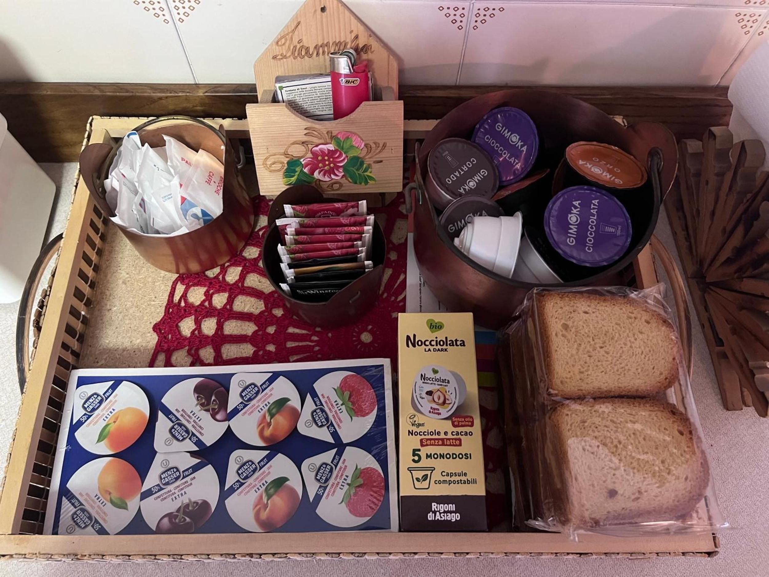 Ein Tablett mit verschiedenen Speisen, darunter Brot, verpackten Snacks und einer Packung Nocciola La Dark.
