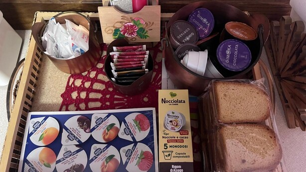 Ein Tablett mit verschiedenen Speisen, darunter Brot, verpackten Snacks und einer Packung Nocciola La Dark.