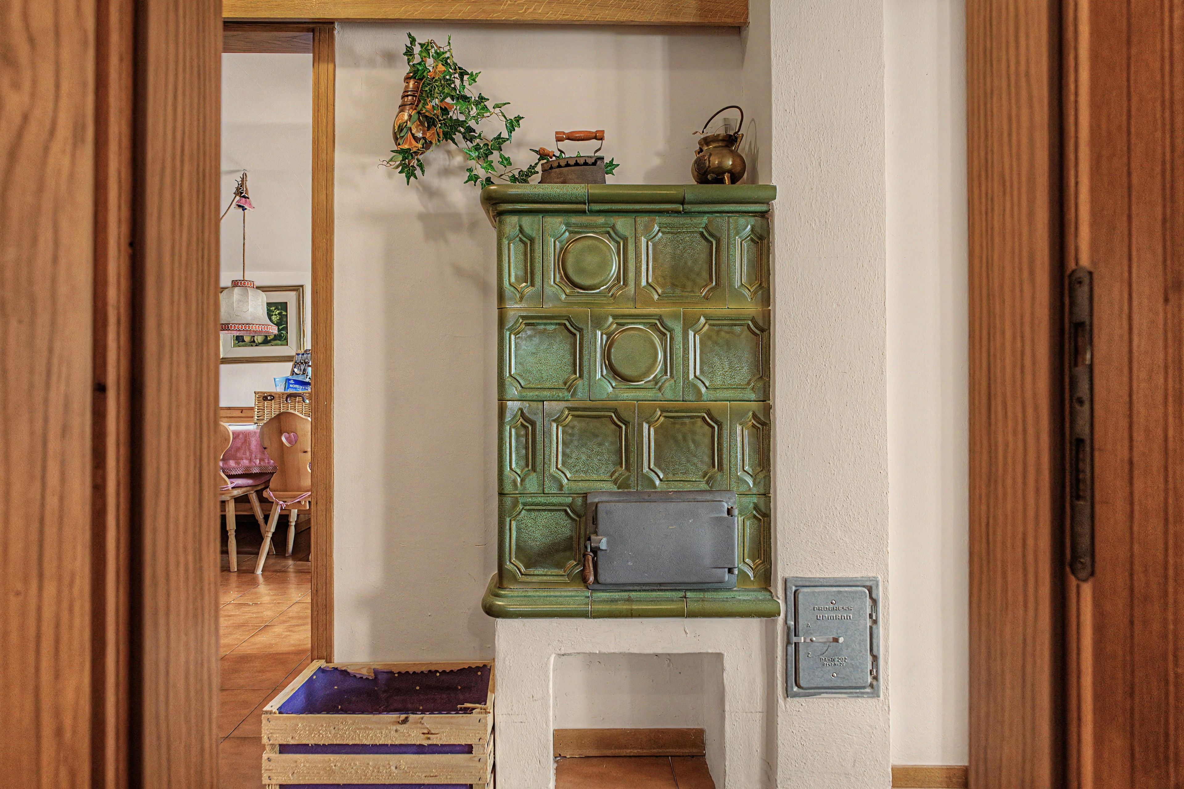Une pièce avec un meuble vert, une chaise en bois et une petite table sur laquelle est posée une plante.