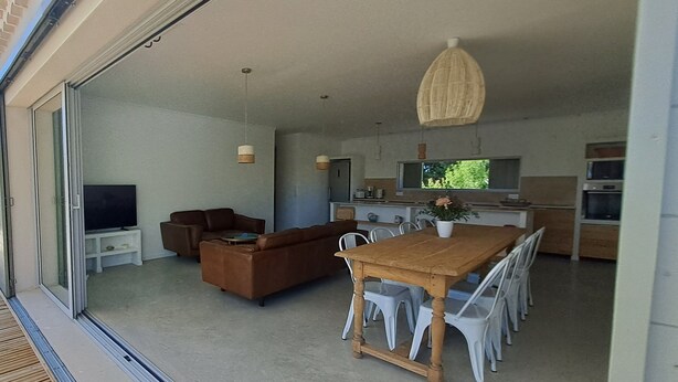 A modern kitchen with a dining area, a television, and a large window. - Vrbo Property (Richerenches)