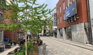 A street with a cinema, outdoor seating, and a building with a sign for 'CINEMAS'. - Vrbo Property (Montréal)