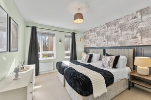 A bedroom with a bed, bedside tables, a dresser, and a window with curtains. - Charming Maya Boutique Inn - Garden (Manchester)