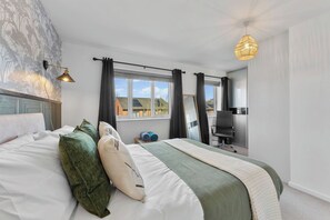 A bedroom with a bed, a desk, a chair, a lamp, and a window with curtains. - Charming Maya Boutique Inn - Garden (Manchester)