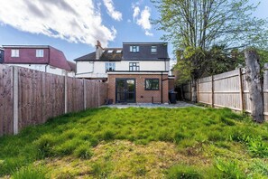 A residential property with a fenced backyard, a brick house, and a tree. - Stunning 6 bedroom in Wembley - Parking (London)