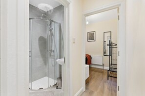 A modern bathroom with a glass shower enclosure, a white sink, and a walk-in shower. - Stunning 6 bedroom in Wembley - Parking (London)