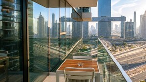 Un balcón con mesa y sillas, con vistas a la ciudad.