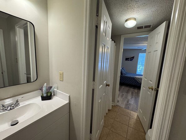 A bathroom with a sink, mirror, and a towel rack.