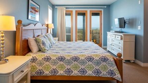 A bedroom with a bed, a dresser, a television, and a ceiling fan. - RARE Short-term rental on Exclusive Pine Island! Oceanfront&Pool, Oct 8-11, 2026 (Corolla)