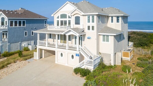 A two-story beachfront house with a balcony, a garage, and a clear view of the ocean. - RARE Short-term rental on Exclusive Pine Island! Oceanfront&Pool, Oct 8-11, 2026 (Corolla)
