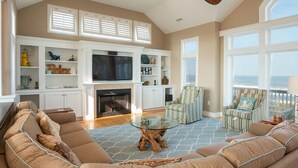 A spacious living room with a fireplace, comfortable seating, and large windows. - RARE Short-term rental on Exclusive Pine Island! Oceanfront&Pool, Oct 8-11, 2026 (Corolla)