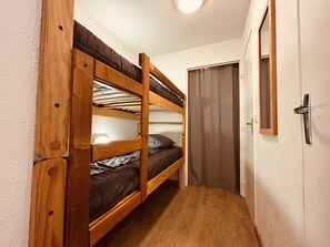 A bunk bed with a wooden frame and a door with a handle. - Bright studio ski slopes view for (Les Deux Alpes)