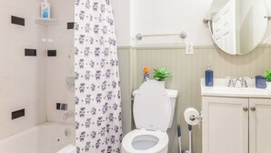 A bathroom with a shower, toilet, sink, and mirror. - Modern Studio in Allentown (Buffalo)