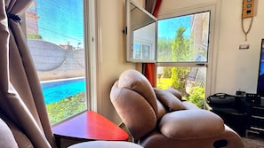 A room with a large window, a red table, and a large plush toy.