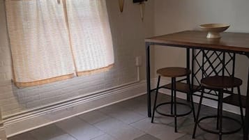 A kitchen with a window, a table, two chairs, and a countertop.