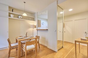 A modern interior with a dining area, wooden furniture, and a minimalist design. - Elegant Apartment Arc de Triomphe Trocadero (Paris)