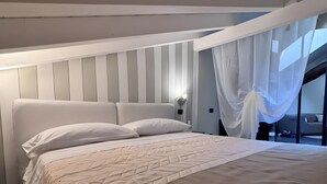 Een moderne slaapkamer met een groot bed, een hoofdeinde en een nachtkastje.