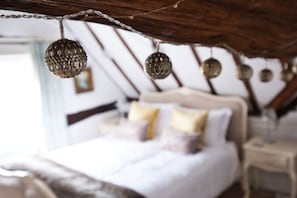 A bedroom with a bed, pillows, and hanging decorative items. - The Royal Exchange House in Canterbury (Kent)