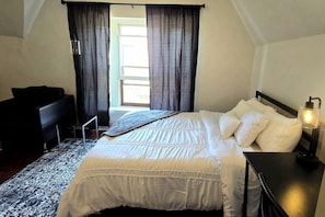 A bedroom with a bed, a desk, and a lamp. - Prime Economy Penthouse (Buffalo)