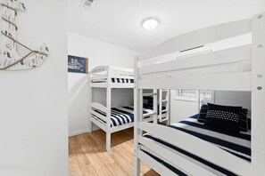 A bunk bed room with white walls and a wooden floor. - 🏖️ The Sandbox 🏖️🚶 Walk to Beach 🌊🏡 Fenced Yard 🌳 (Panama City Beach)