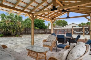 An outdoor patio with a pergola, wicker furniture, and a hammock. - 🏖️ The Sandbox 🏖️🚶 Walk to Beach 🌊🏡 Fenced Yard 🌳 (Panama City Beach)