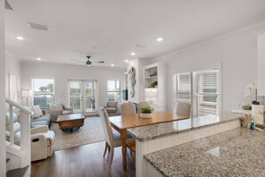 A spacious living area with a dining table, seating, and a ceiling fan. - 🌊Seabreeze 30A | Beach Across Street | Bikes | Community Pool (Inlet Beach)